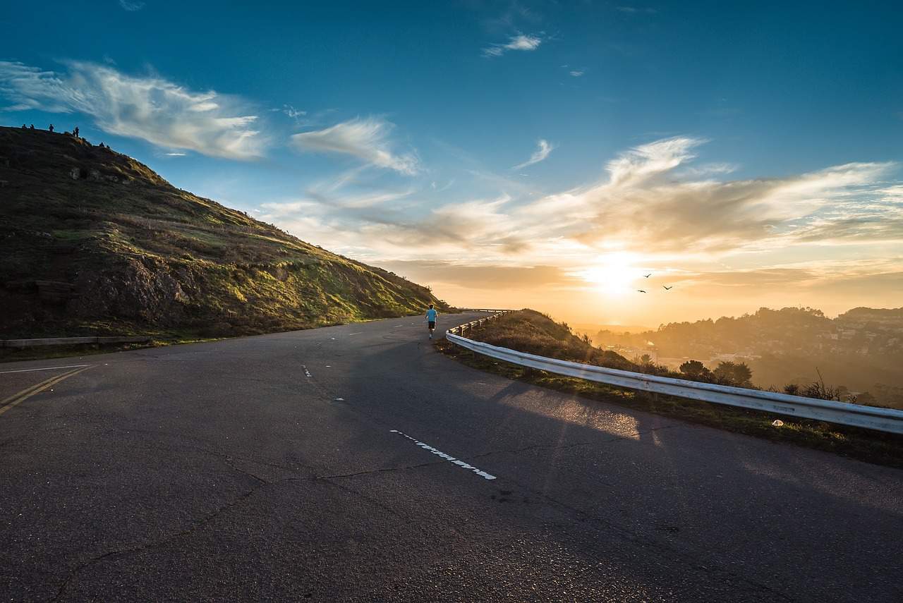 person running on road at sunrise