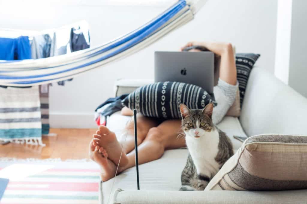 Girl on couch with her laptop watching movies