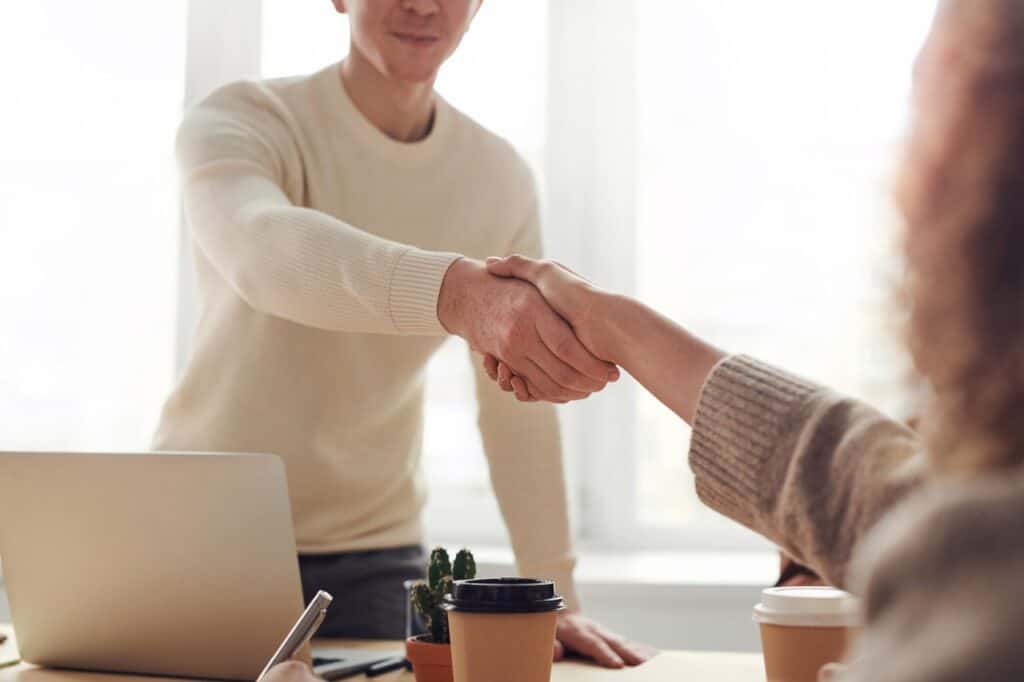 man shaking woman's hand